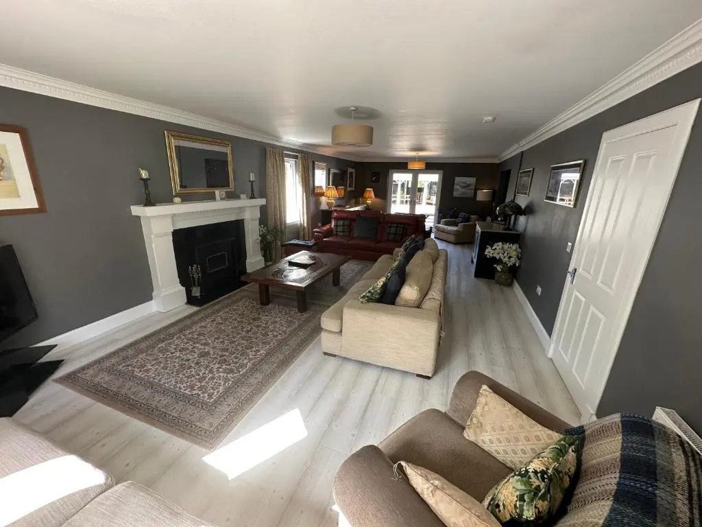 a living room with two couches and a fireplace at Cardon House - luxury Highland holiday home in Inverness