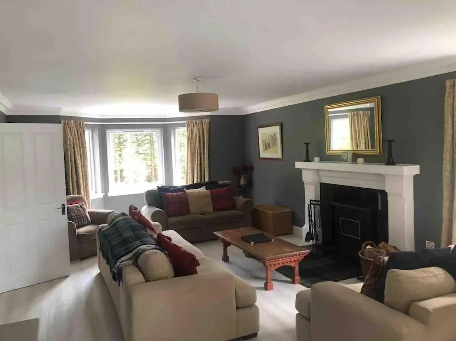a living room with couches and a fireplace at Cardon House - luxury Highland holiday home in Inverness