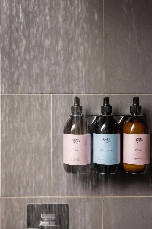 three bottles of soap on a shelf in a bathroom at The Hayloft in Banchory