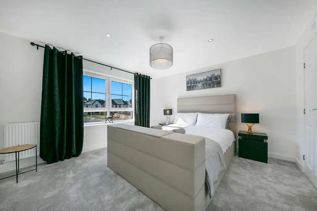 a bedroom with a bed and a large window at Fern Place Villa - Grampian Lettings Ltd in West Cults