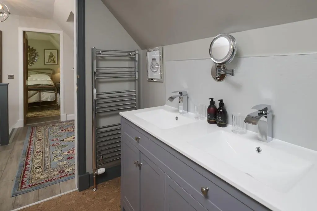 a bathroom with two sinks and a mirror at Balnacraig Farmhouse in Inverness