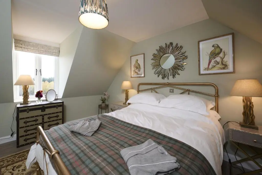 a bedroom with a bed and a mirror on the wall at Balnacraig Farmhouse in Inverness