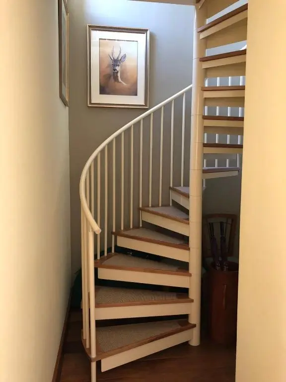 a stairway with a wooden stair case in a house at The Highland Club in Fort Augustus