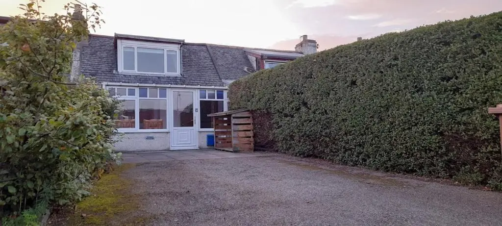 a house with a large hedge next to a garage at Sunnyside Cottage 2 Bedrooms 1 Bathroom 1 WC 2 Pets Welcome in Hilton of Cadboll