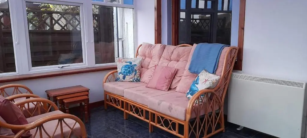 a couch sitting on a porch next to a window at Sunnyside Cottage 2 Bedrooms 1 Bathroom 1 WC 2 Pets Welcome in Hilton of Cadboll