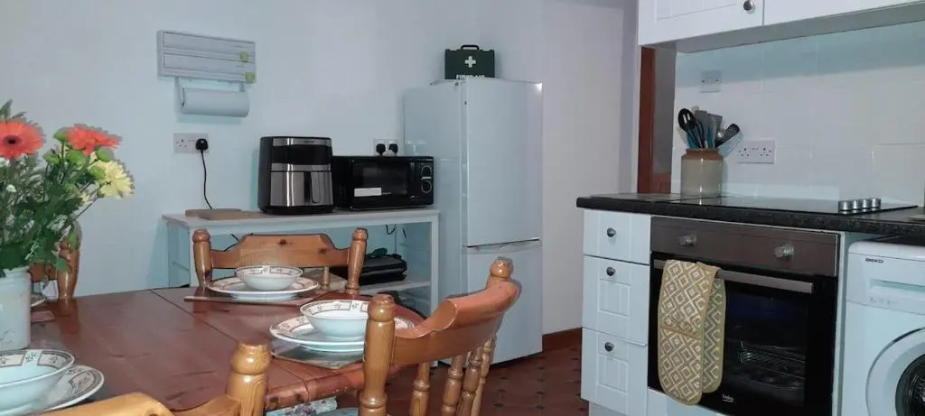 a small kitchen with a table and a microwave at Sunnyside Cottage 2 Bedrooms 1 Bathroom 1 WC 2 Pets Welcome in Hilton of Cadboll