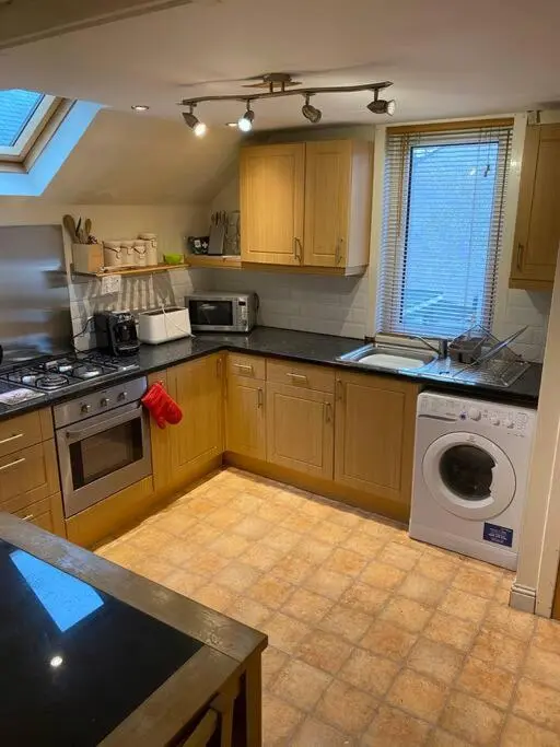 a kitchen with a stove and a washing machine at 47 High Street in Alness