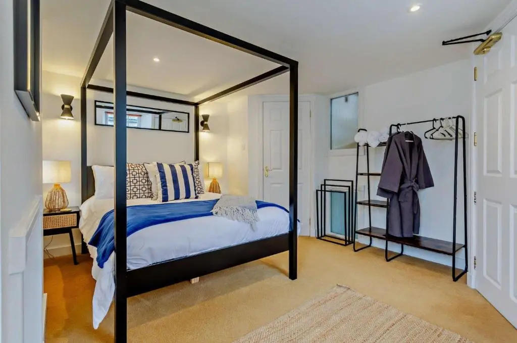 a bedroom with a canopy bed with a blue blanket at Jacobite's Retreat, 17th century cottage in the heart of Inverness in Inverness