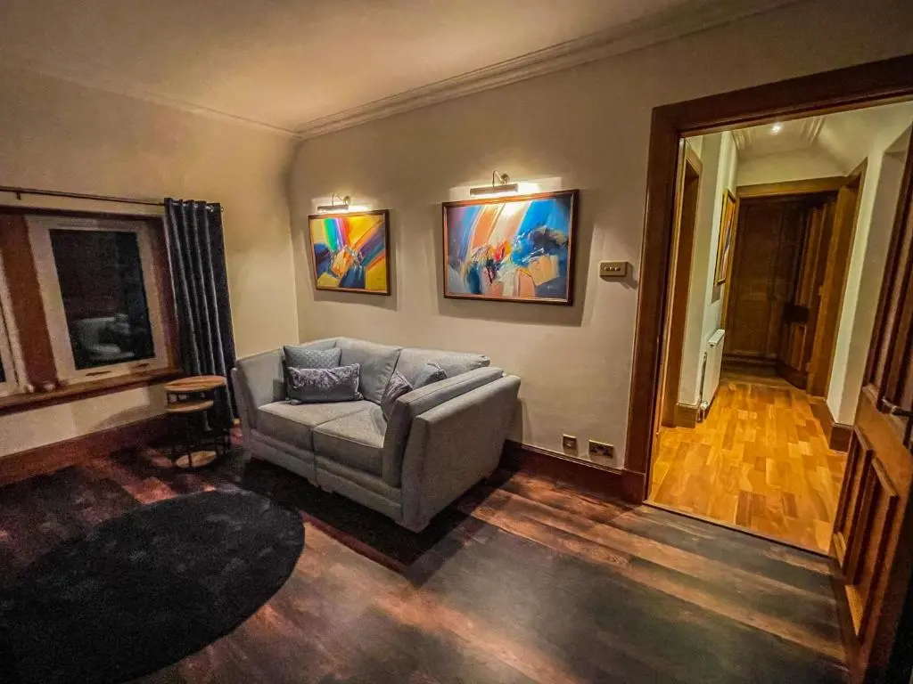 a living room with a couch and paintings on the wall at Cathedral Apartment in Inverness