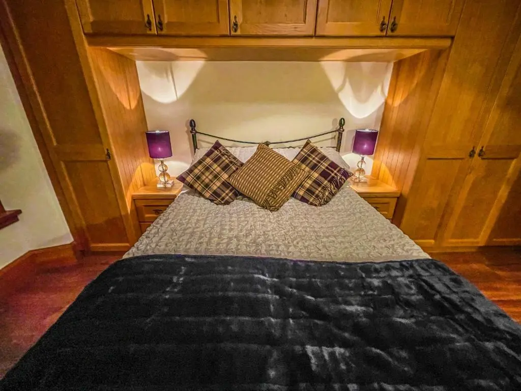 a bedroom with a bed with pillows on it at Cathedral Apartment in Inverness