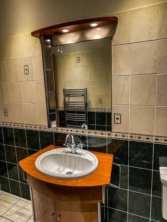 a bathroom with a sink and a mirror at Cathedral Apartment in Inverness