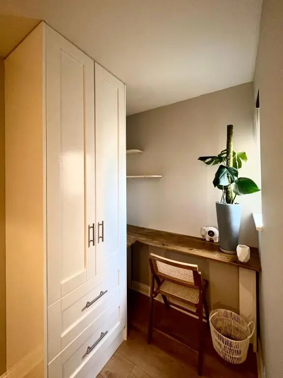 a room with a desk and a cabinet and a plant at Lossie Self-Catering Apartment in Lossiemouth