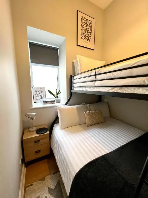 a small bedroom with a bunk bed and a window at Lossie Self-Catering Apartment in Lossiemouth