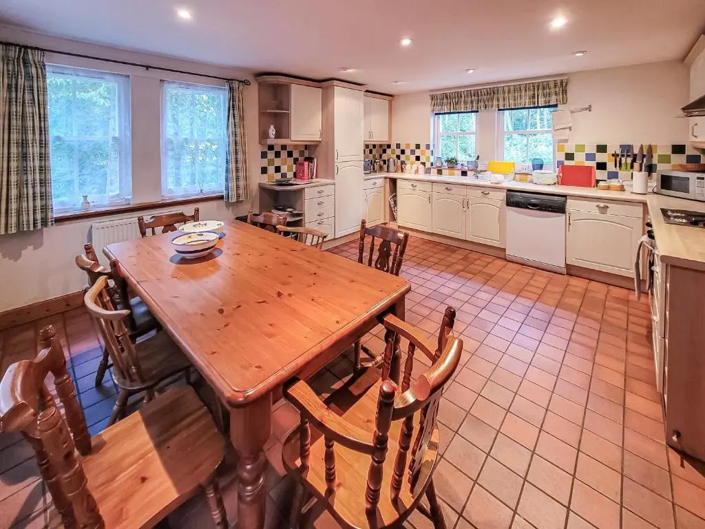 a kitchen with a wooden table and chairs at South Lodge in Banchory