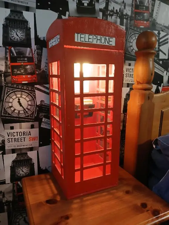 a red telephone box sitting on top of a table at The Hideaway Inverurie in Inverurie
