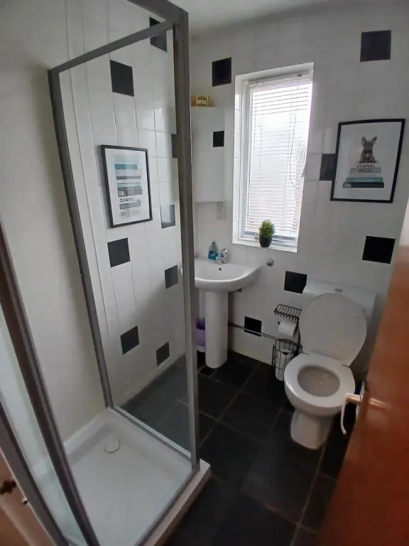 a bathroom with a shower and a toilet and a sink at The Hideaway Inverurie in Inverurie