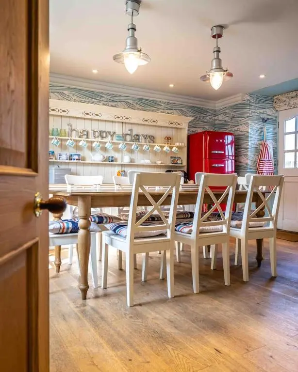 a kitchen with a table and chairs and a red refrigerator at The Millie Luxury Five Star with Sea View in Burghead