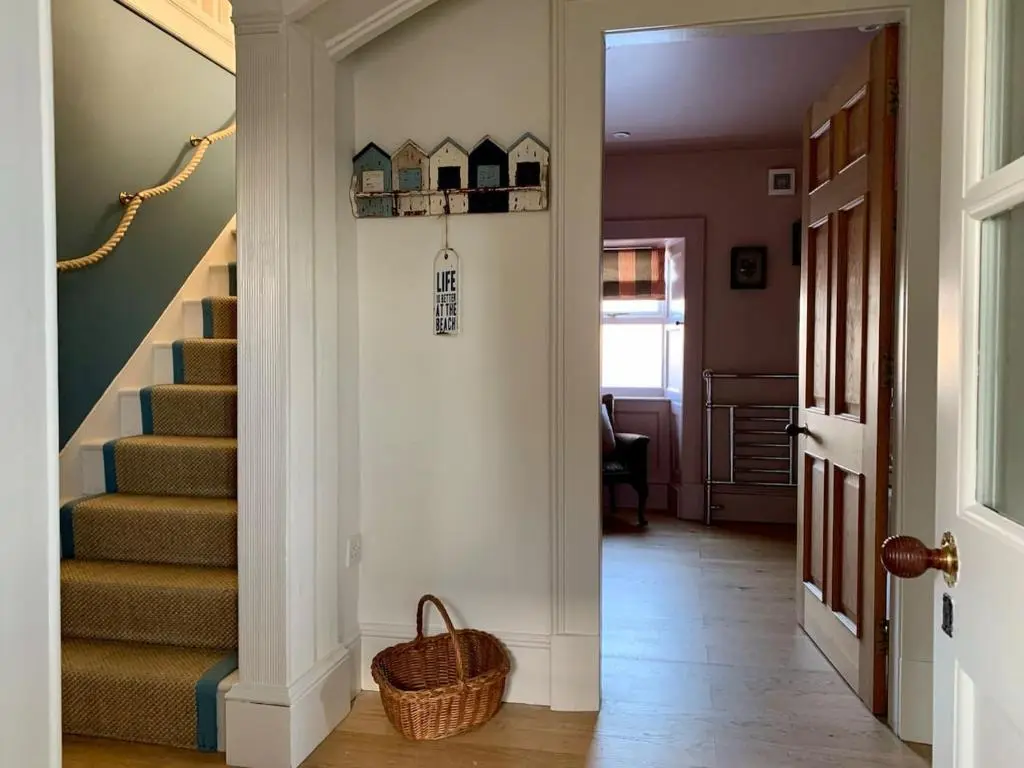 a hallway with stairs with a basket on the floor at The Millie Luxury Five Star with Sea View in Burghead