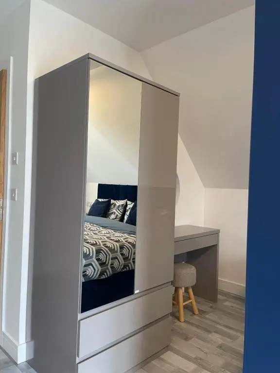 a bedroom with a large mirrored cabinet with a bed at Lochside Loft - Self Catering Apartment for 2 In a great location for Inverness Airport and both Cabot Highlands & Nairn Golf Courses in Inverness