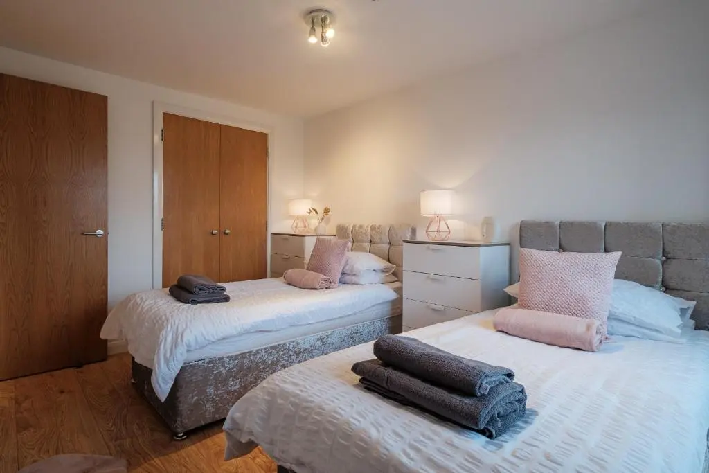 a bedroom with two beds with towels on them at Mackie Residence - SJA Stays - 3 Bed Apartment with parking in Westhill
