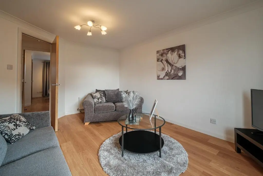 a living room with a couch and a table at Mackie Residence - SJA Stays - 3 Bed Apartment with parking in Westhill