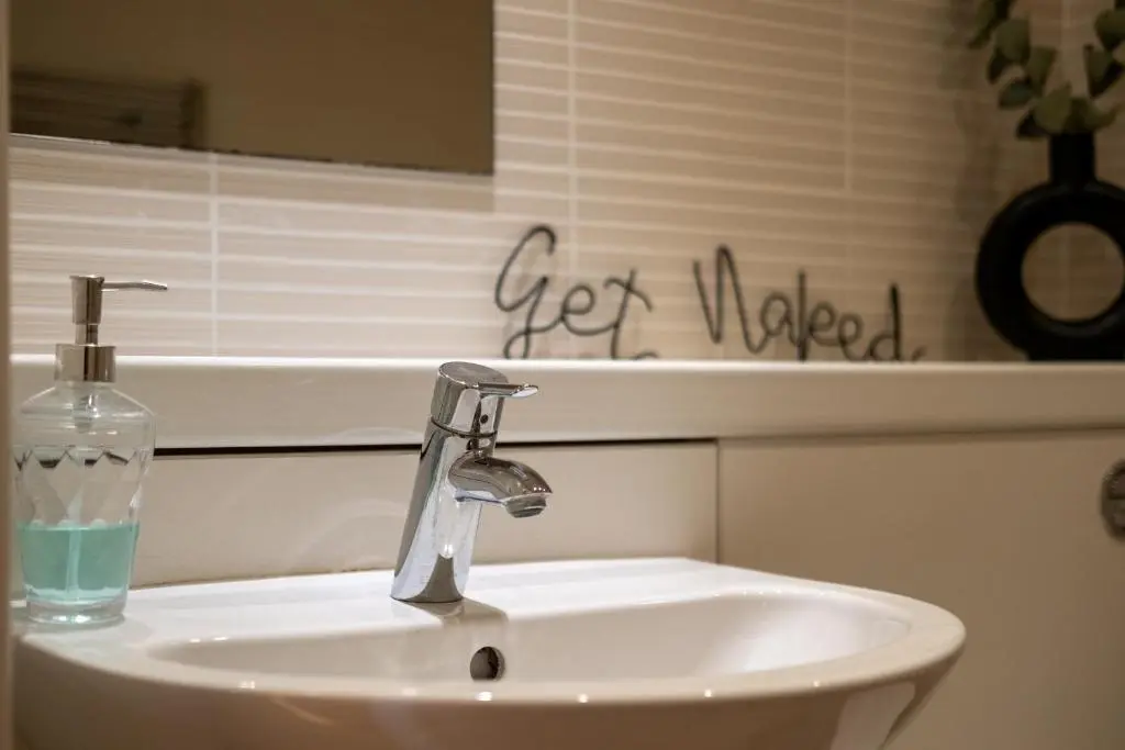 a bathroom sink with a bottle of soap on it at Mackie Residence - SJA Stays - 3 Bed Apartment with parking in Westhill