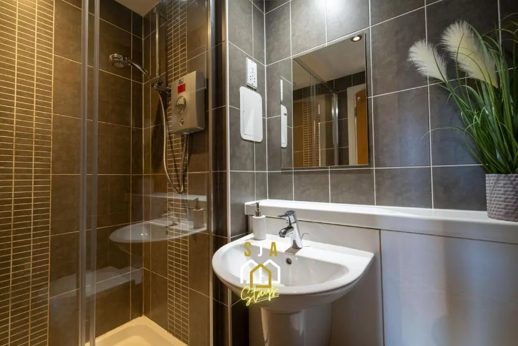 a bathroom with a sink and a mirror at Mackie Residence - SJA Stays - 3 Bed Apartment with parking in Westhill