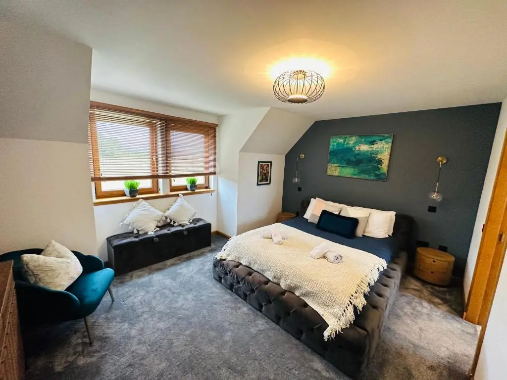 a bedroom with a bed and a couch in it at 1 Woodside in Elgin