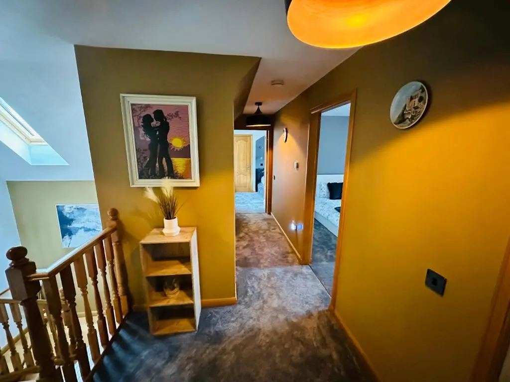 a hallway of a home with yellow walls and stairs at 1 Woodside in Elgin