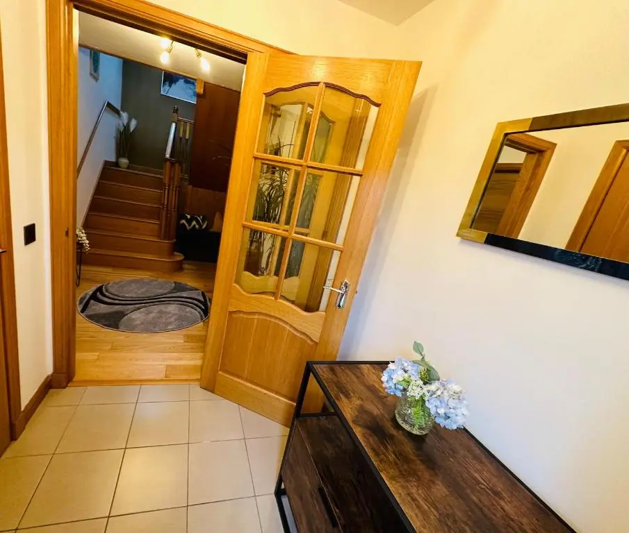 a hallway with a wooden door and a vase of flowers at 1 Woodside in Elgin