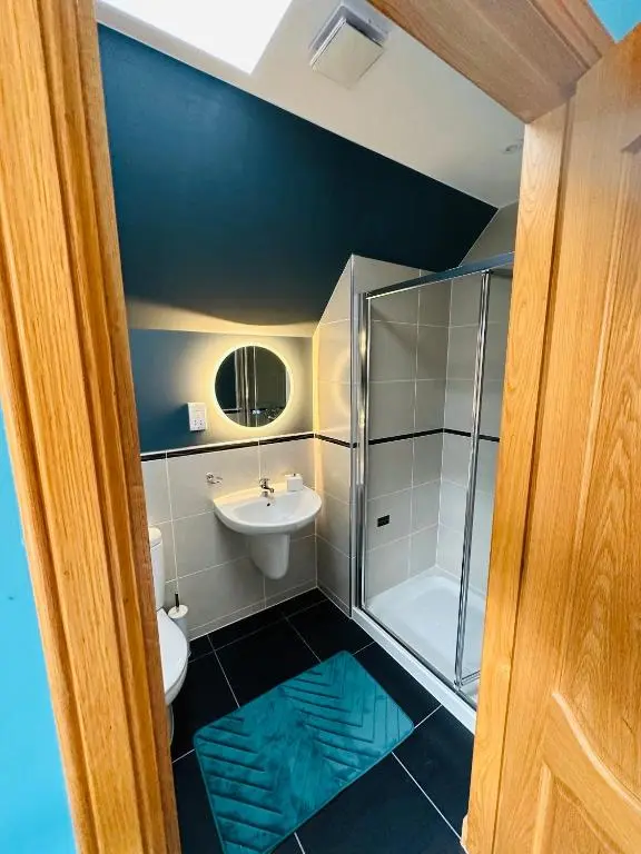 a bathroom with a shower and a sink and a toilet at 1 Woodside in Elgin