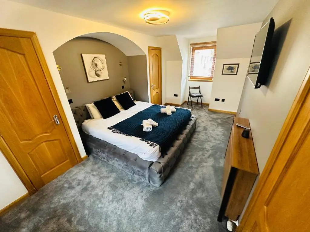 a bedroom with a bed with two stuffed animals on it at 1 Woodside in Elgin