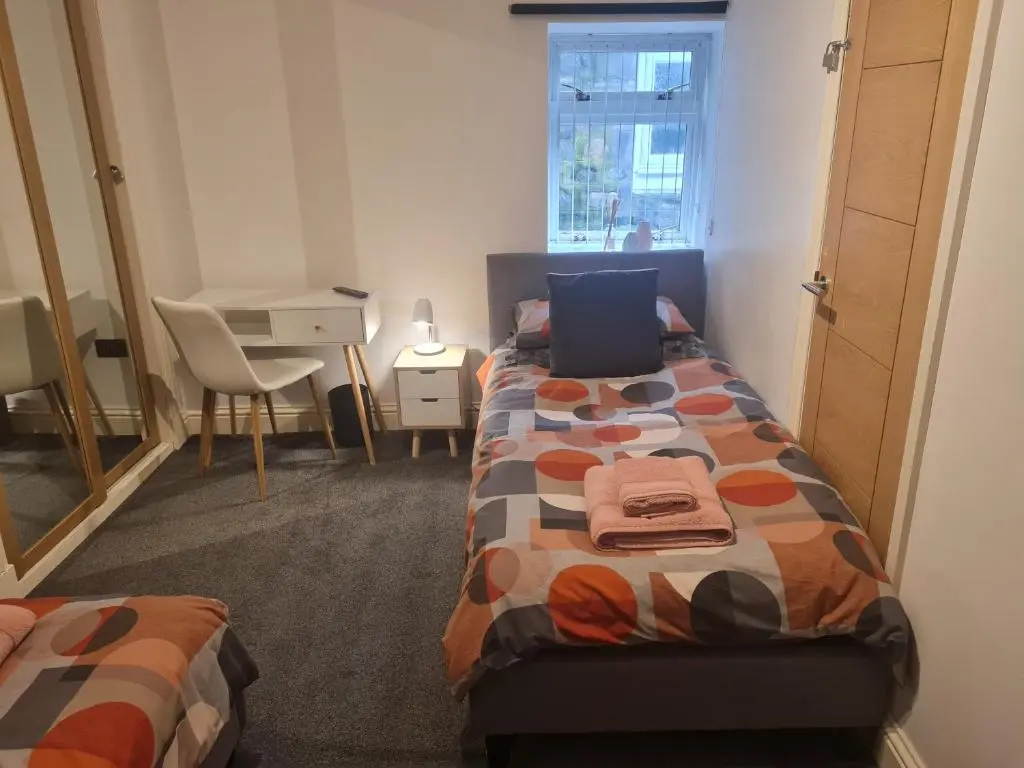 a bedroom with two beds and a table and a desk at Cullen Holiday Home in Cullen