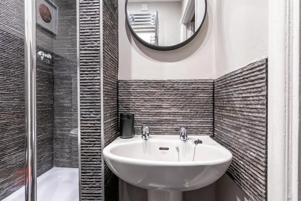 a bathroom with a sink and a mirror at Sweet Ness River Flat in Inverness