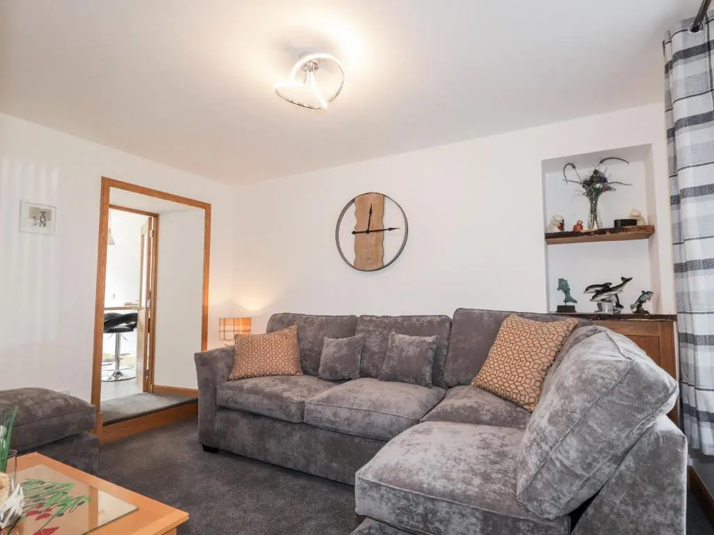 a living room with a couch and a table at Corner Cottage in Buckie
