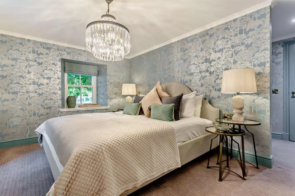 a bedroom with a bed and a chandelier at Cathedral House in Dornoch