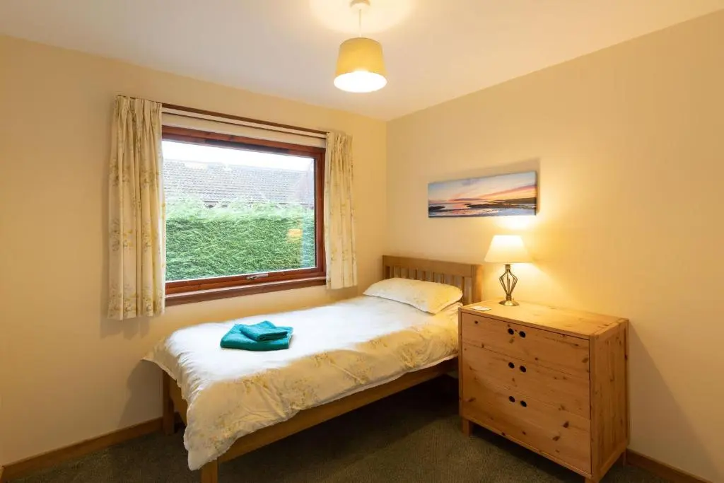 a bedroom with a bed and a window and a dresser at Aonach in Kingussie