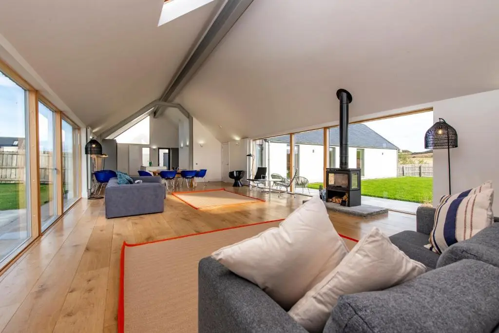 a living room with a couch and a fireplace at Architect Designed Lodge in Dunecht