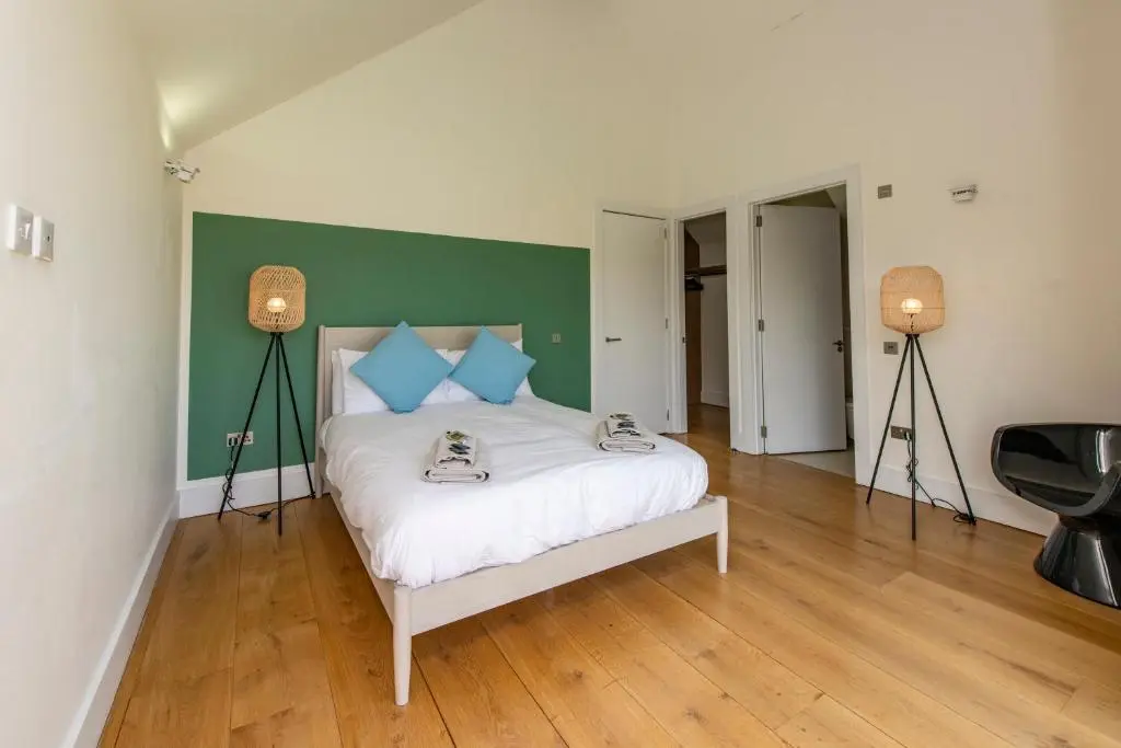 a bedroom with a bed with two lamps on it at Architect Designed Lodge in Dunecht