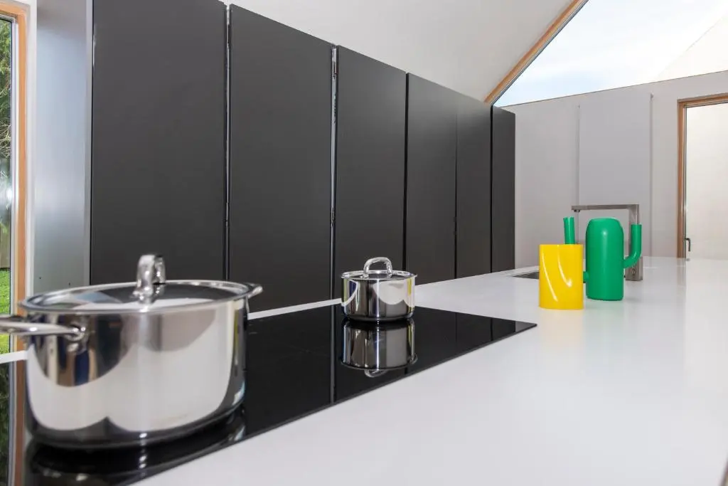 a kitchen with a stove with a pot on a counter at Architect Designed Lodge in Dunecht