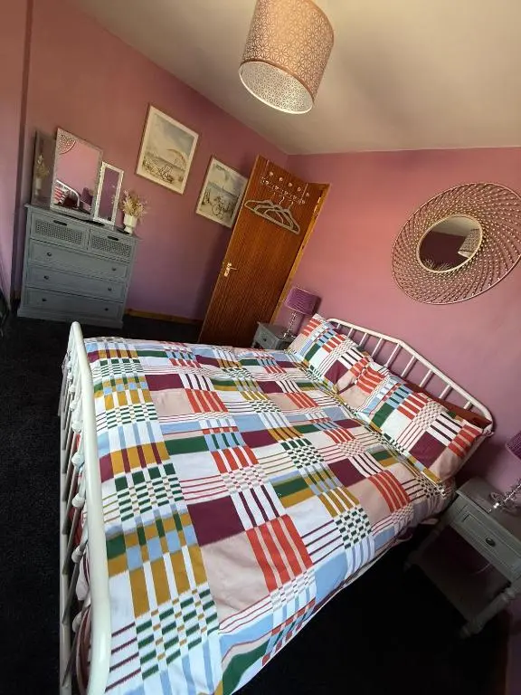 a bedroom with a bed with a colorful quilt at Old Dairy in Tain