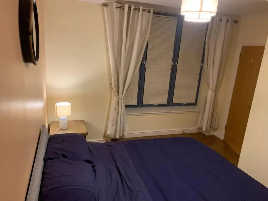 a bedroom with a purple bed and a window at The old post office in Golspie