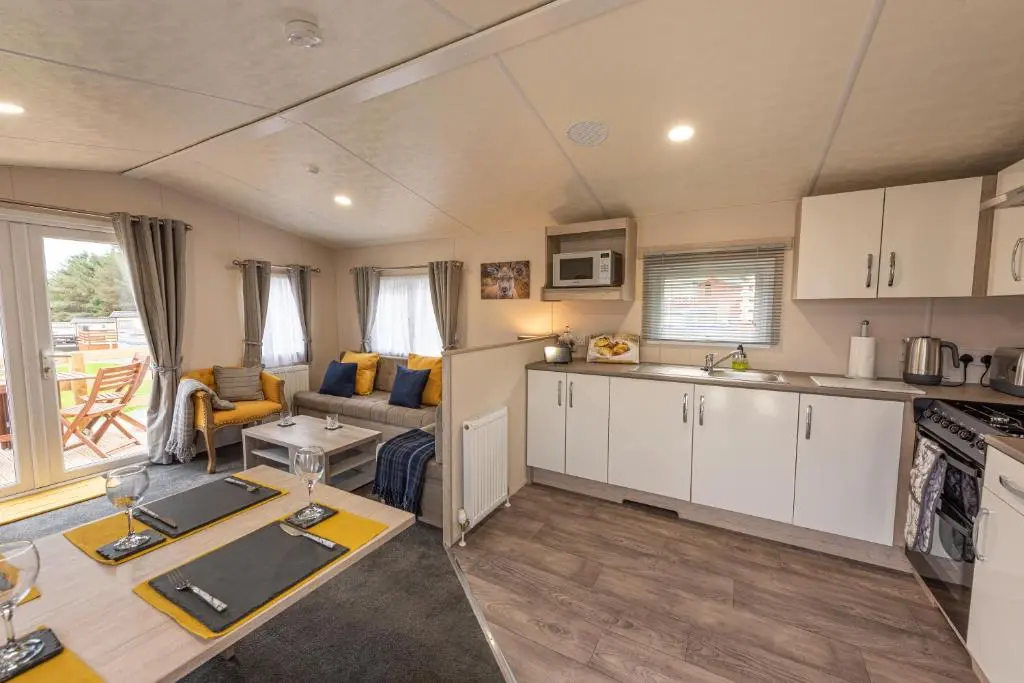a kitchen and living room of a caravan at Highland Chalet - Peaceful Stay near Dornoch in Dornoch