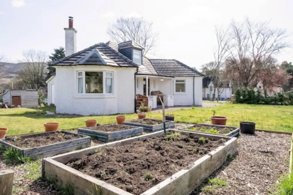 a garden in front of a house at Cosy Hygge/ Scottish themed home by Loch Ness in Fort Augustus