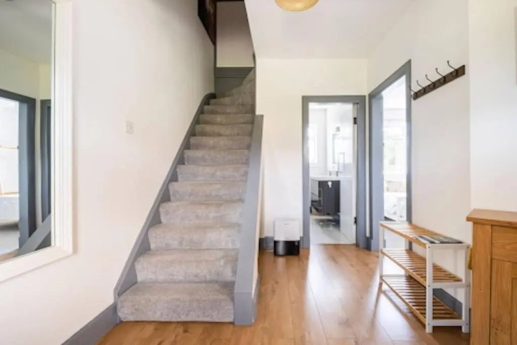 a staircase in a home with white walls and wooden floors at Cosy Hygge/ Scottish themed home by Loch Ness in Fort Augustus
