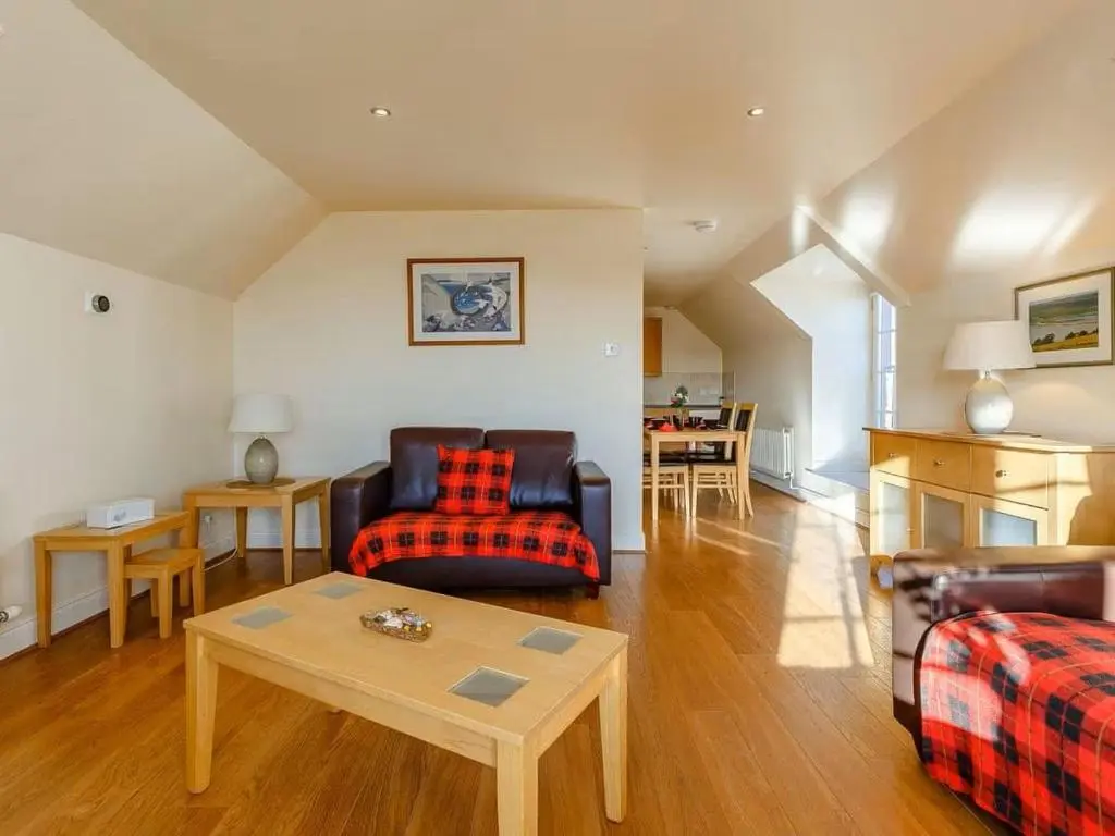 a living room with a couch and a table at Craiglea Barn in Latheron