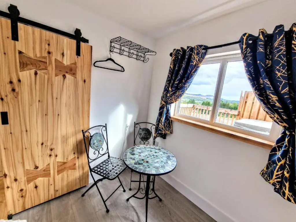 a room with a table and chairs and a window at Kaoglen Lodge - Fawn Pod - Hot Tub - Dogs - Pitlochry - Luxury in Blairgowrie