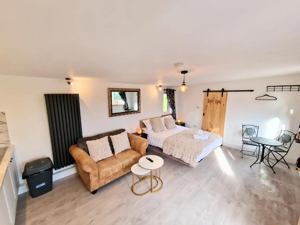 a living room with a couch and a bed at Kaoglen Buck Pod - Hot Tub - Dog Friendly in Blairgowrie