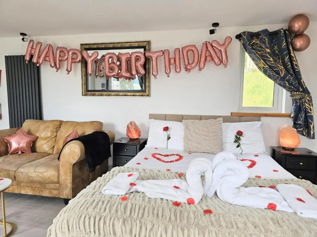 a bedroom with a bed with a happy birthday sign at Kaoglen Buck Pod - Hot Tub - Dog Friendly in Blairgowrie