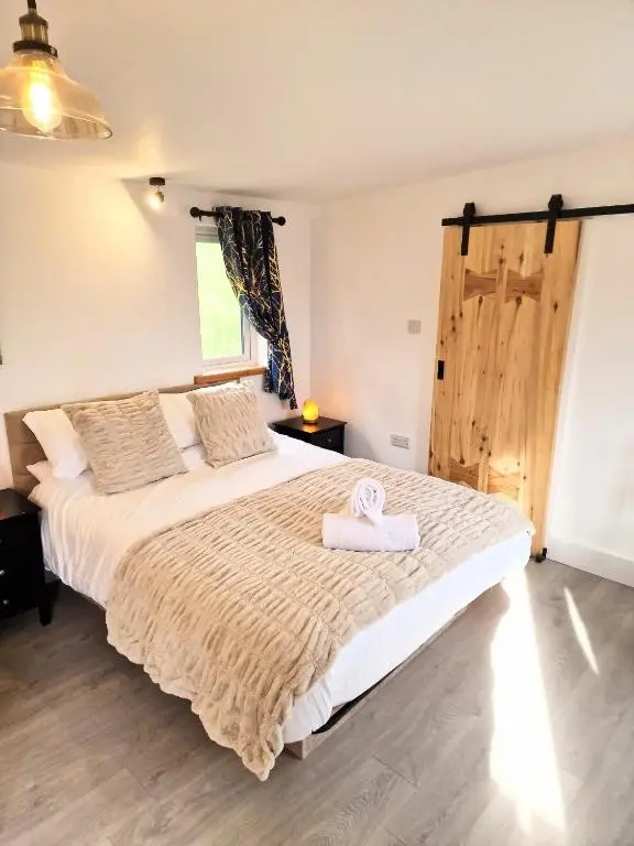 a bedroom with a bed with a towel on it at Kaoglen Buck Pod - Hot Tub - Dog Friendly in Blairgowrie